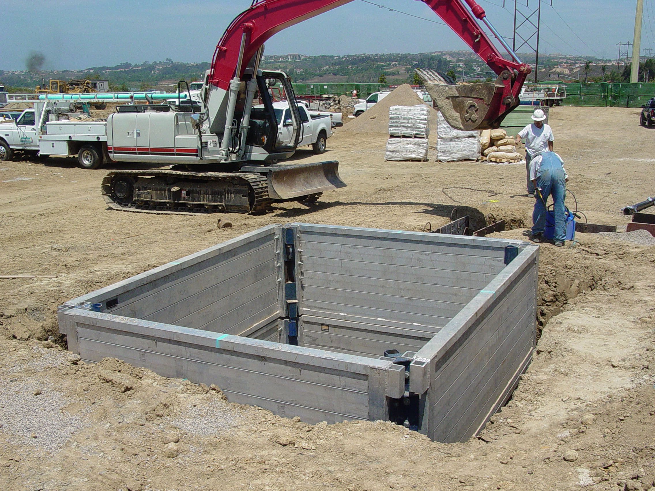 aluminum trench shield being used in the ground at trench shoring job site