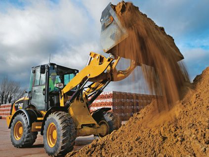 CAT wheel loader adding dirt to large pile at work site