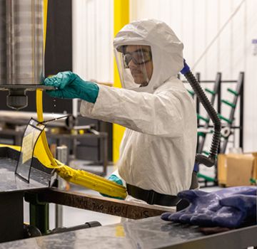 Carter Cat employee in a white hazmat suit performing a service