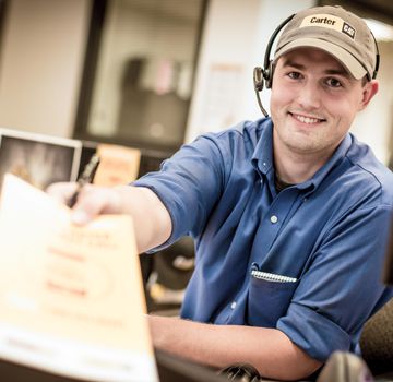 A Carter Cat employee smiling and handing over a piece of paper