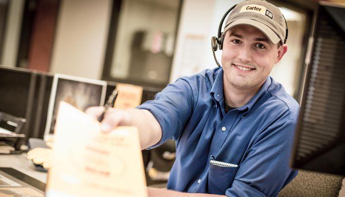 A Carter Cat employee smiling and handing over a piece of paper