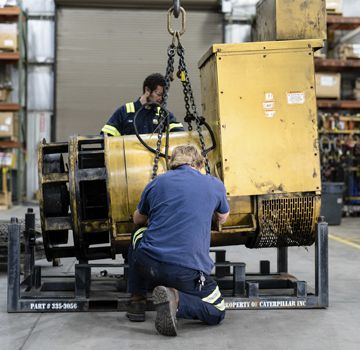 Two Carter Cat employees servicing a power system