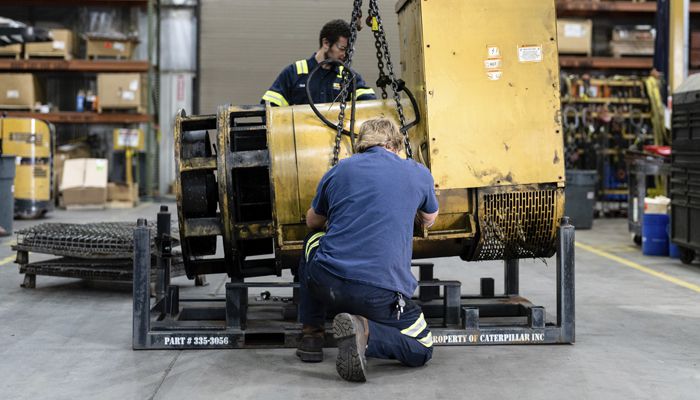 Two Carter Cat employees servicing a power system