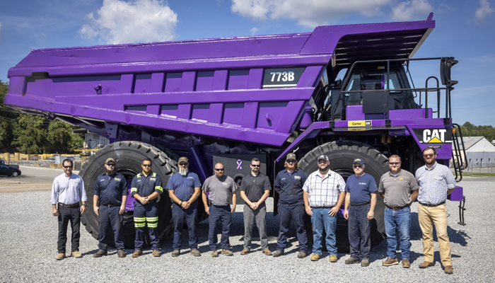 11 Carter Cat employees standing in front of a Purple Cat Haul Truck