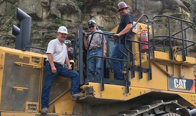 4 men checking out a Cat machine