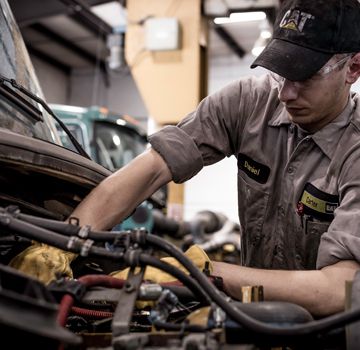 A Carter Cat employee working on a piece of machinery