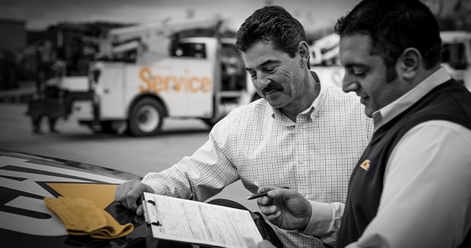 Two Carter Cat employees looking a clipboard