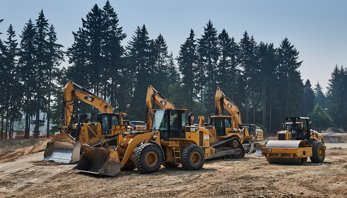4 different cat machines in a field of dirt